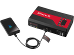 A black smartphone charging from a red and black portable power supply.