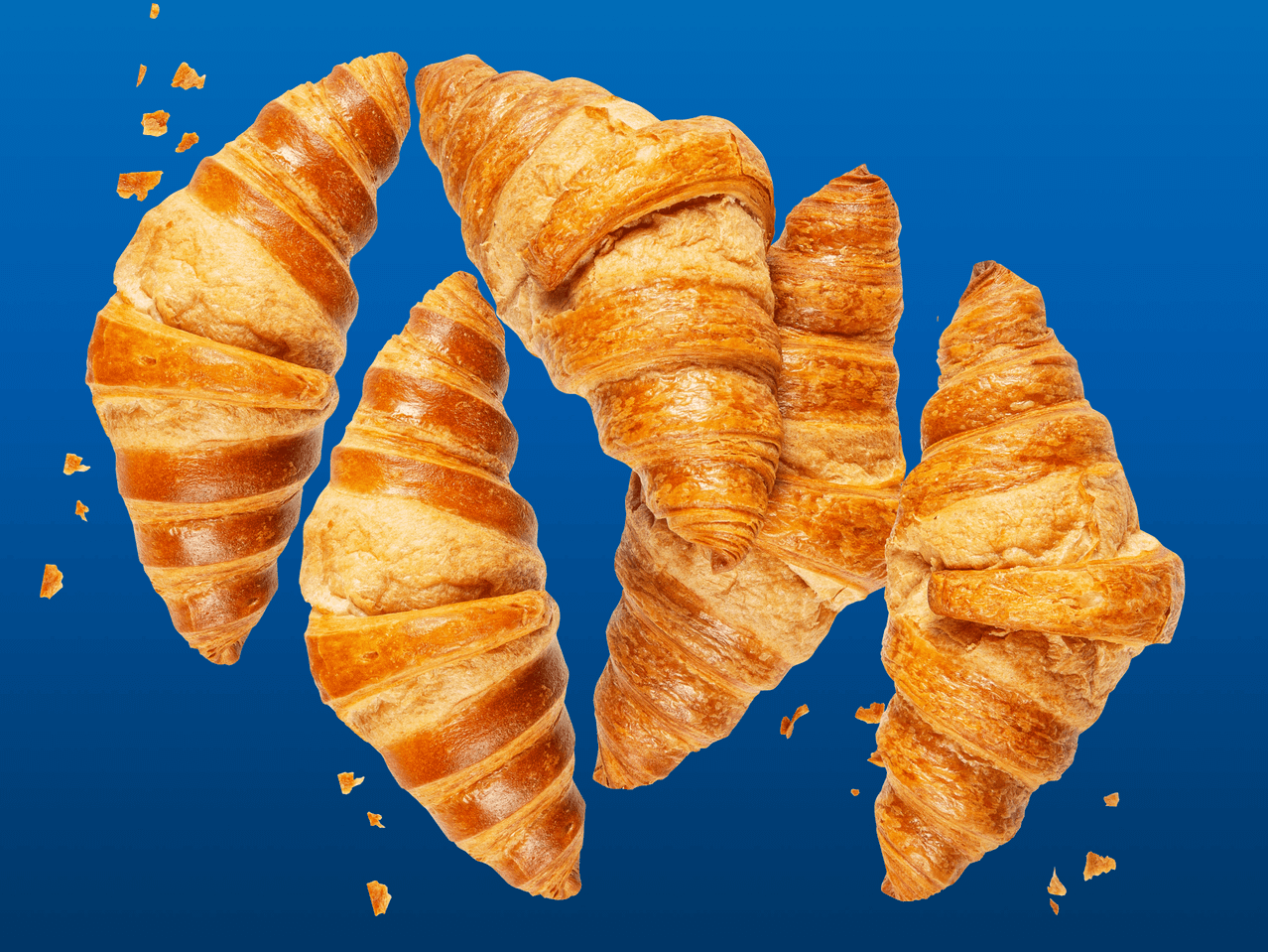 Neljä murtuneena olevaa croissanttia sinisellä taustalla.