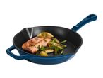Cooked salmon fillet with asparagus and lemon in a blue cast iron skillet.