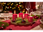 Set aus 4 roten Adventskerzen mit goldenen Zahlen auf einem festlichen Tisch