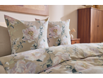 Conjunto de roupa de cama floral com almofadas e edredão em tons bege e rosa