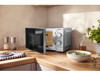Micro-ondas SILVERCREST na bancada da cozinha, aberto, com configurações de cozedura visíveis.