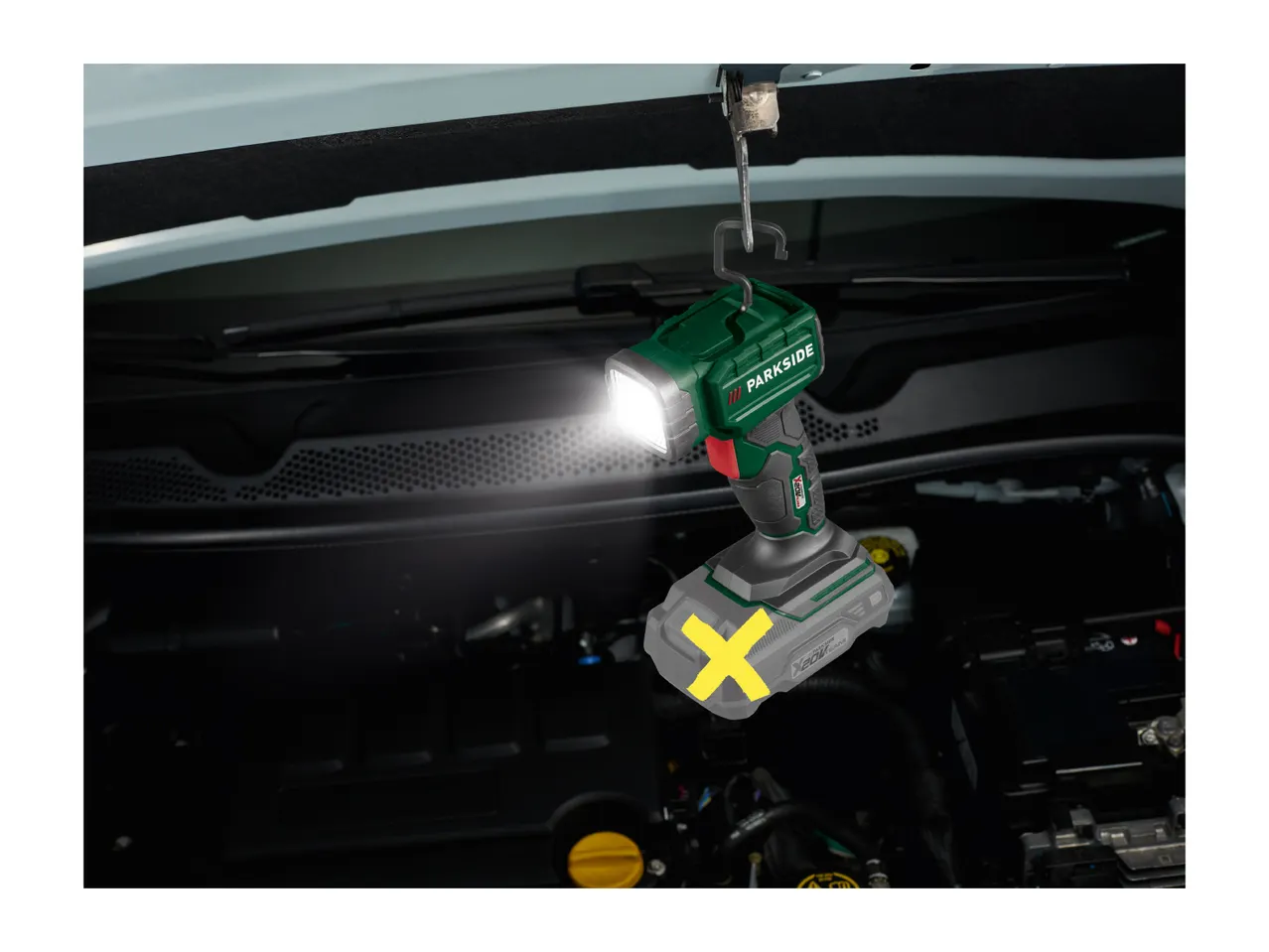 Parkside cordless work light illuminating a car engine bay.