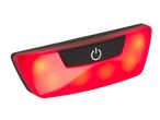 Red bicycle rear light with a power button, glowing brightly.