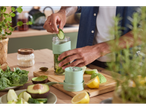 Bărbat prepară smoothie cu blenderul Silvercrest®, adăugând castravete în sticlă.