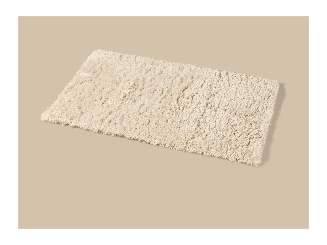 Cream-colored rectangular shag rug on a beige background.