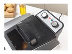 A deep fryer with potatoes and oil in the background, showing temperature and timer dials.