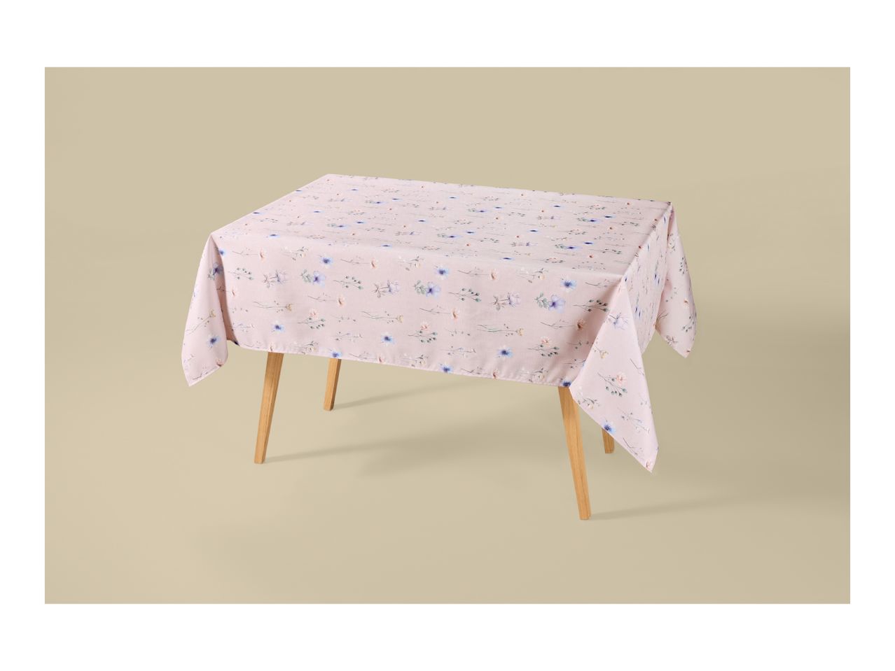 Pink floral tablecloth on a wooden table with a light background.