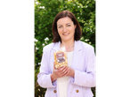 Woman holding a bag of Second Street Bakeshop Gourmet Toffee Popcorn.