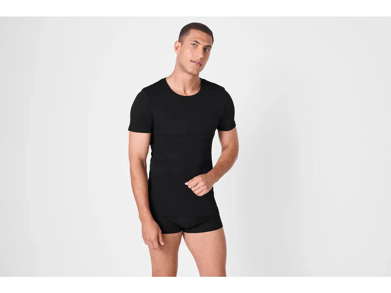 Muškarac u crnoj uskoj majici i boksericama.