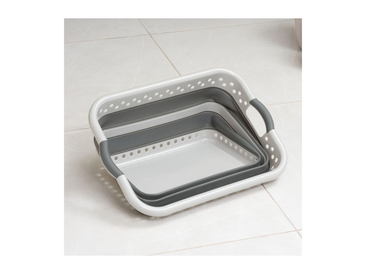 Three collapsible laundry baskets nested together on a tiled floor.