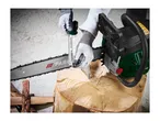 A person wearing protective gloves uses a file guide to sharpen a chainsaw chain.