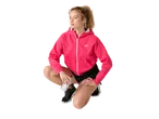 Woman in a pink hoodie and black shorts, holding a water bottle, in a squatting pose.