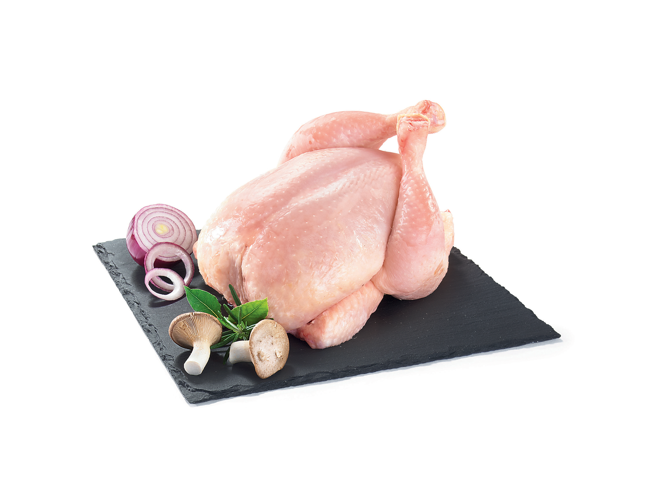 Frango cru, cebola e cogumelos em ardósia preta.