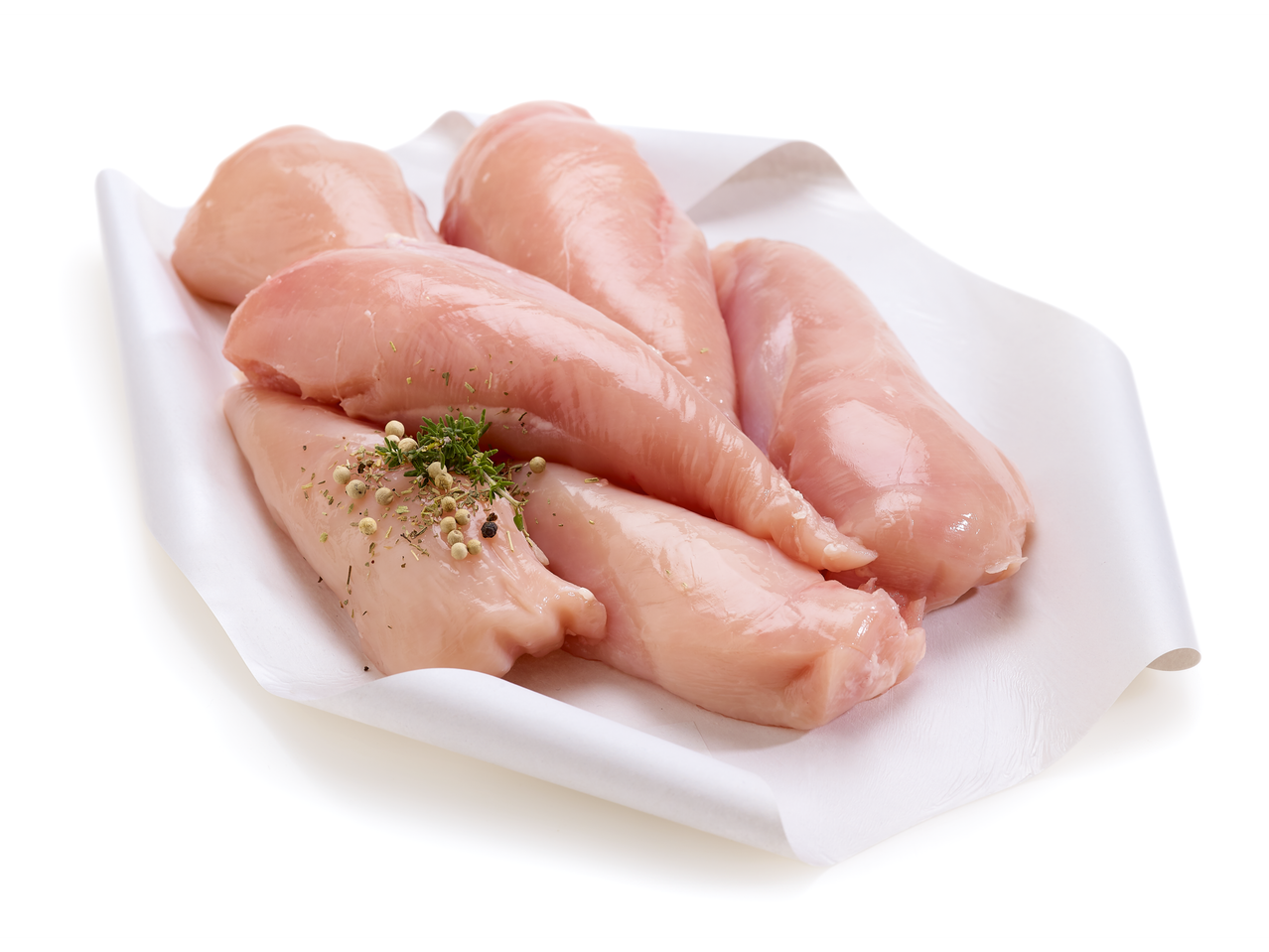 Filets de poitrine de poulet crus avec herbes et grains de poivre sur papier blanc.