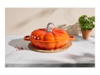 Orange pumpkin-shaped cast iron casserole dish on a wooden board