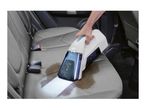 Handheld spot cleaner removing a stain from a car seat.