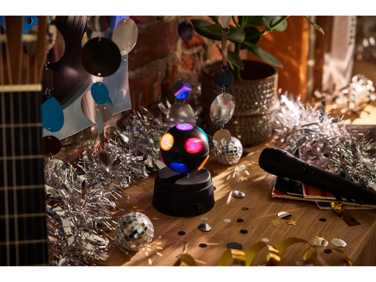 Livarno LED-Partyleuchte und Partydekorationen auf einem Holztisch.