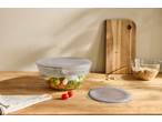 Tampas de silicone Silvercrest® em tigelas de salada e cereais, sobre uma mesa de madeira.