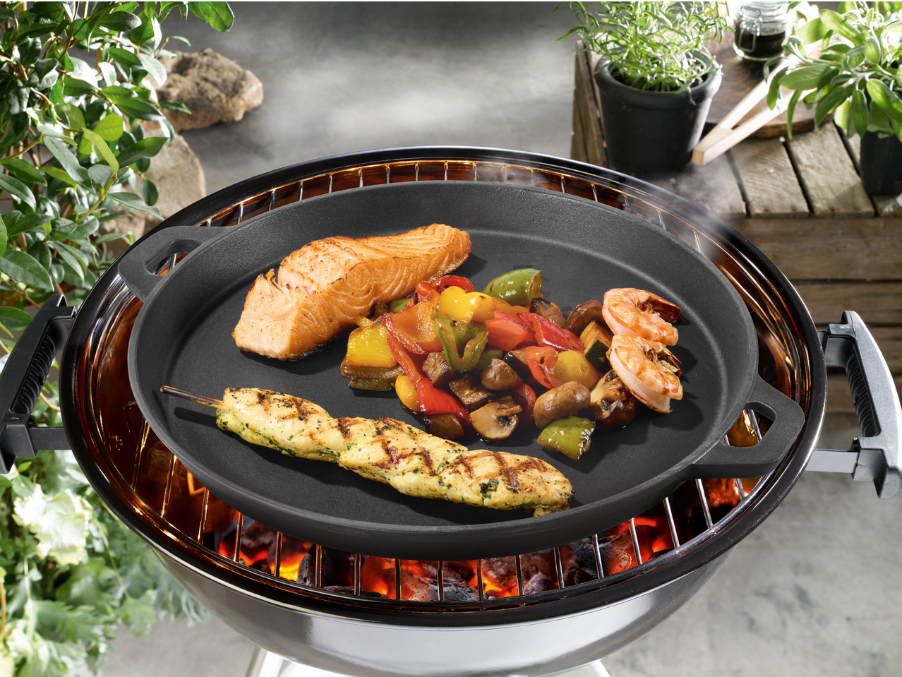 Grillmeister Cast Iron Grill Pan/Plate with salmon, vegetables, shrimp, and chicken skewer on a grill.