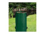 Green garden waste bag filled with leaves, set against a pond and lush greenery.